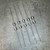 Five axial lead glass cartridge fuses 1A 250V laid out on gray backdrop