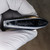 Black Swagelok lever handle showing molded wordmark, flow arrow, scuffs and tan residue