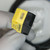 Banner sensor QS18VP6AF100 visible on yellow housing, adjustment screw slot intact, clear indicator lens, no visible wear.