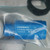 Factory-sealed bag with IO-Link M18 body, marked LLR-M18PA-NMS-60D, serial 1115574 E, CE marked. Mounting hardware visible inside bag.