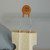 Marked "22 / 1KV" on orange epoxy body; both radial leads straight and unsoldered, stored in original paper sleeve.
