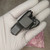 Adapter cradled in a gloved palm showing the black crinkle-finish body and threaded top connector.