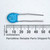Murata 332M-MX ceramic disc capacitor beside a millimeter ruler showing dimensions.