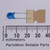 Blue disc body marked 32K and 11V visible on face; two straight silver leads approximately 12mm long; body spans roughly 7mm at ruler.