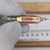 Glass-encapsulated hermetic axial resistor; red print reads 1.47MEG and serial 7611920. Clear glass body, gold-toned element, fine axial leads. No visible damage.