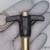 Black T-handle body stamped CARRLANE and partial code 17985 visible; Gold-zinc finish shankshank extends above and below; knurled handle edges; light surface marks on handle face.
