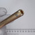 Gold-zinc finish hollow shank end with machined recessed bore, surface patina and light tarnish overall, small circular stamp near tip.