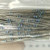 Axial-lead resistors with blue bodies and multicolor band markings, long straight leads, loose bulk quantity visible.