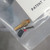 Gold-plated connector with hex fitting and barbed stem; two short leads with black and red insulation visible, no visible damage.