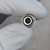 Face-on view of BNC female jack body; silver-plated outer shell, white PTFE dielectric, gold center pin intact with no visible damage.