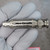 Nickel-plated cylindrical body with BNC male connector; light surface wear visible; partial code readable on left end: ...236...