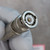 Silver-finish male BNC connector face-on, white PTFE dielectric visible, gold center pin intact, bayonet slots clear of damage.
