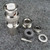 Nickel-plated body with knurled coupling ring, white dielectric visible at face. All hardware pieces present: hex nut, lock washer, flat washer, rubber grommet, and center pin.