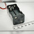Black plastic 2x2 stacked AA holder; red and black lead wires, metal spring contacts visible, two screws and mount holes on end face.