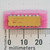 Bourns 4116R-001-101 16-pin DIP resistor network on pink foam next to a metric scale.