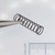 Close-up of Century Spring V-72CS compression spring held with tweezers.