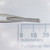 Close-up of Century Spring LL-80CS compression spring held with tweezers.