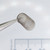 Angled view of Century Spring W87-CS compression spring held with tweezers.