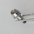 Front view of PartsMine A-6044 chrome LED bezel cup held in tweezers.