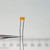 Yellow radial capacitor marked 471 A1K held in tweezers.