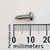 Side view of a NEWCO 14085 screw against a millimeter ruler.