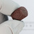 Even Cut FLAT-TOP-60 abrasive cap held in gloved hand showing abrasive grit texture.