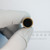 Hollow mounting opening of Even Cut FLAT-TOP-60 abrasive cap held in gloved fingers.