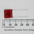 Top view of red ECQ-B2104JF capacitor next to a millimeter ruler showing dimensions.