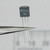 Close-up of NTE 46 transistor held in tweezers showing part markings.