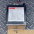 Abbott CC120D1.0 power supply next to a ruler measuring approximately 3 inches wide.