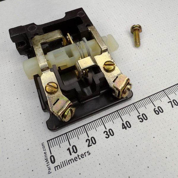 Close-up view of a mechanical relay component with brass connectors and a spring assembly, part of the Joslyn Clark KPM-35 Conversion Kit for PM Relays from PartsMine.com, placed on a dotted background with a millimeter ruler for scale.