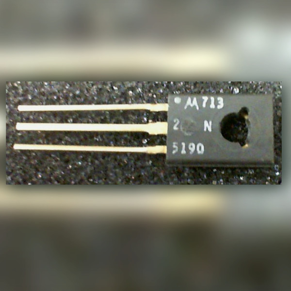 Motorola 2N5190 transistor, TO-126 case with mounting hole and three gold-coloured leads, dark speckled surface