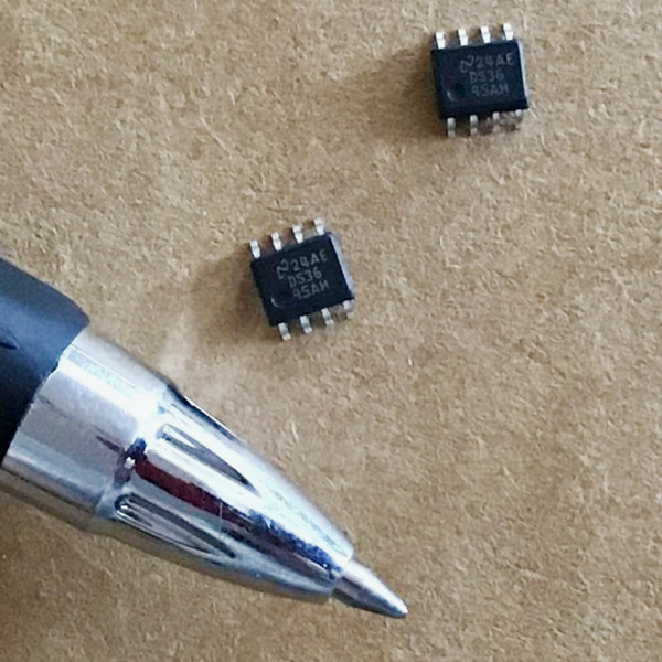 Two National Semiconductor DS3695AM SOIC-8 chips marked DS36 95AM beside a pen tip on brown background