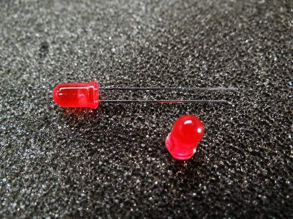 Two diffuse red 5mm LEDs shown unlit; both domed lenses intact, leads straight and untrimmed, no visible damage.