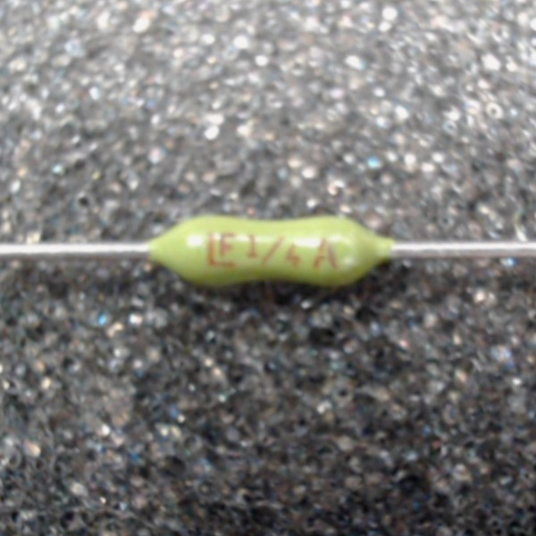 Olive-green subminiature axial fuse on straight wire leads, red body printing reads LF 1/4 A