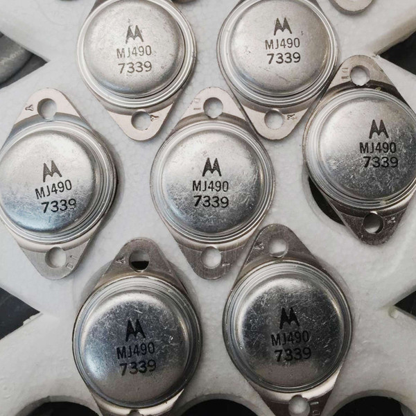 Motorola MJ490 TO-3 transistor cap with batwing logo beside other TO-3 cans on a white surface