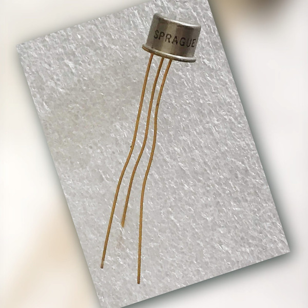 Sprague TQ-59 metal can transistor with three leads beside a handwritten note reading Sprague TQ-59