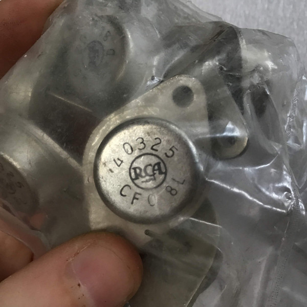 Closeup of a silver RCA 40325 vintage transistor in a classic TO3 metal case, clearly displaying the stamped 'RCA' logo, '40325' model number, and 'CF0 8L' manufacturing code on its circular top. The electronic component is shown inside a clear plastic bag with other similar transistors, indicating new old stock (NOS) condition, perfect for vintage amplifier repair, classic electronics restoration, or as a rare replacement part.
