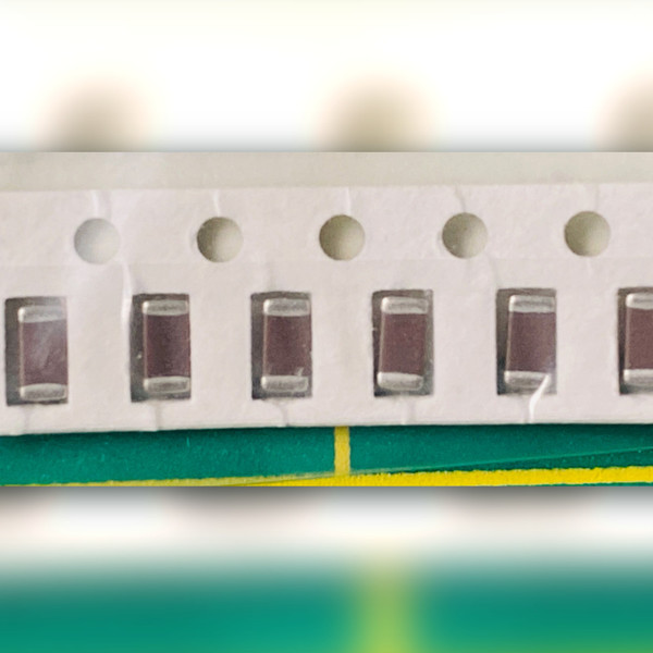 Row of seven brown ceramic chip capacitors with silver-grey end terminations, one cut off at left