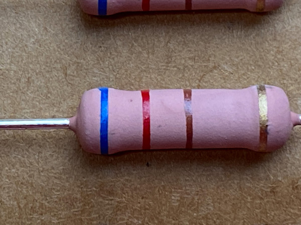 Close view of pink-bodied axial resistor banded blue, red, brown and gold