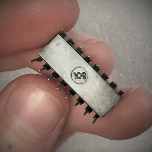 RCA CD4053BE 16-pin DIP held in fingers, underside showing circled molded mark reading 109 this way up