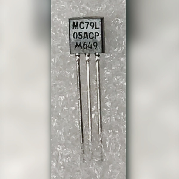 Black TO-92 marked MC79L 05ACP M649 with three long straight leads, grey background.