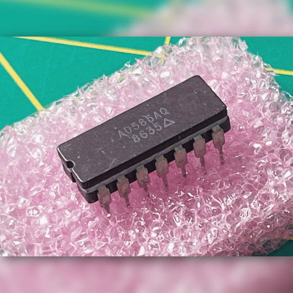 Analog Devices AD585AQ sample-and-hold amplifier in a 14-pin DIP package inserted in pink foam.