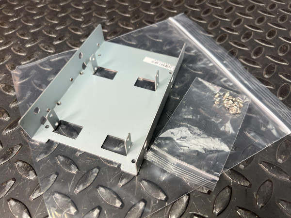 SilverStone drive bay adapter showing clean, unused condition with no visible wear or scratches. Includes small bag of mounting screws.