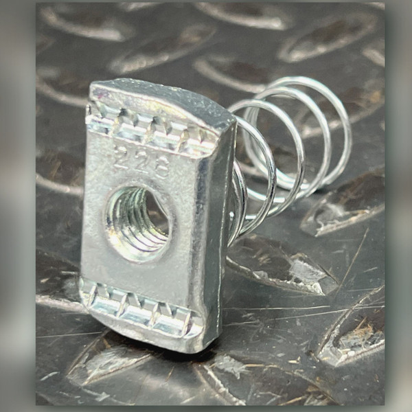 Channel spring nut on dark tread plate, raised 228 marking above threaded hole