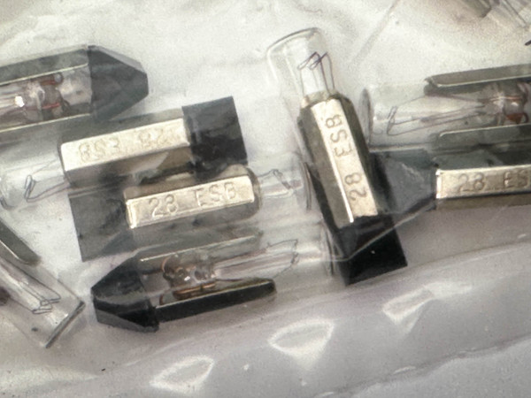 Close-up view of several Sylvania 28ESB Miniature Lamps with T-2 slide bases from PartsMine.com, showing the small glass bulbs with attached metal slide bases marked “28 ESB.”