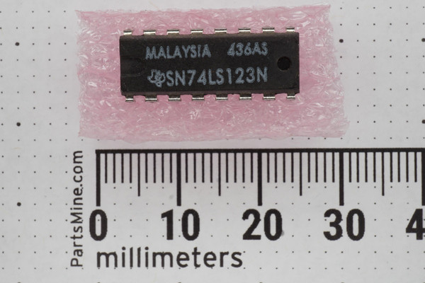 Texas Instruments SN74LS123N 16-pin DIP marked MALAYSIA 436AS on pink anti-static foam above millimeter ruler