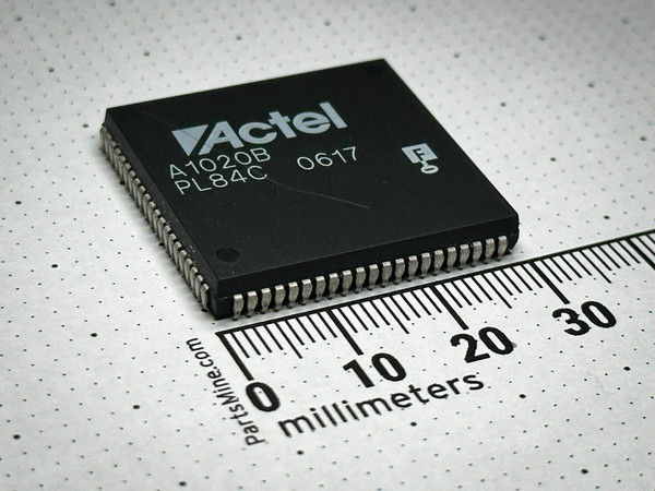 Angled view of Actel A1020B-PL84C ACT 1 FPGA, 84-pin PLCC, bright J-leads, millimeter ruler