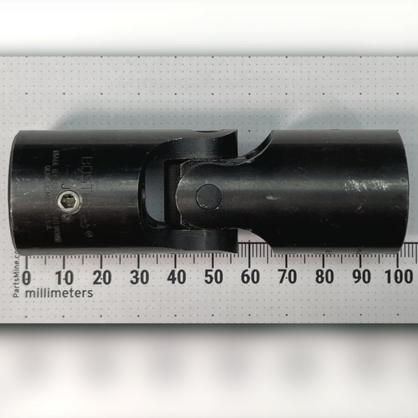 Boston Gear J125 universal joint lying against a millimeter ruler, reading roughly 108 mm across the scale