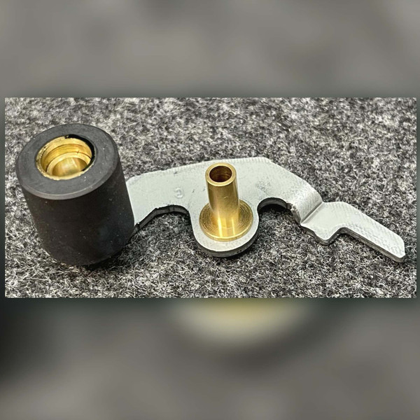 Close angled view of Sony pinch roller arm, black rubber roller and brass pivot bushing
